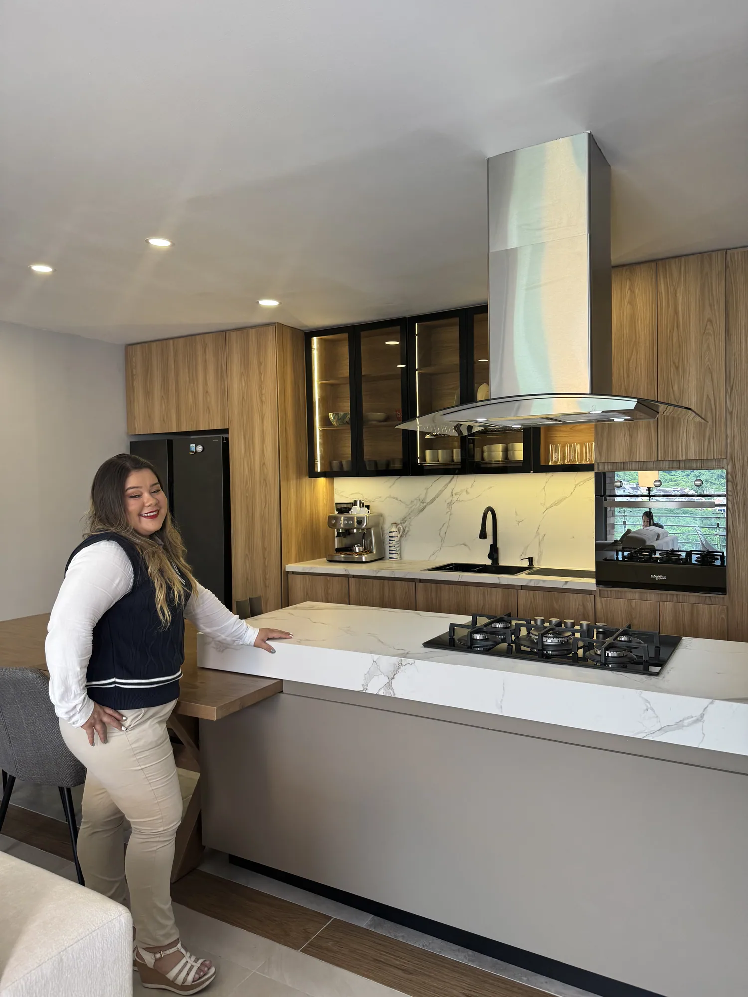 Cocina integral en madera con isla central, campana y meson claro